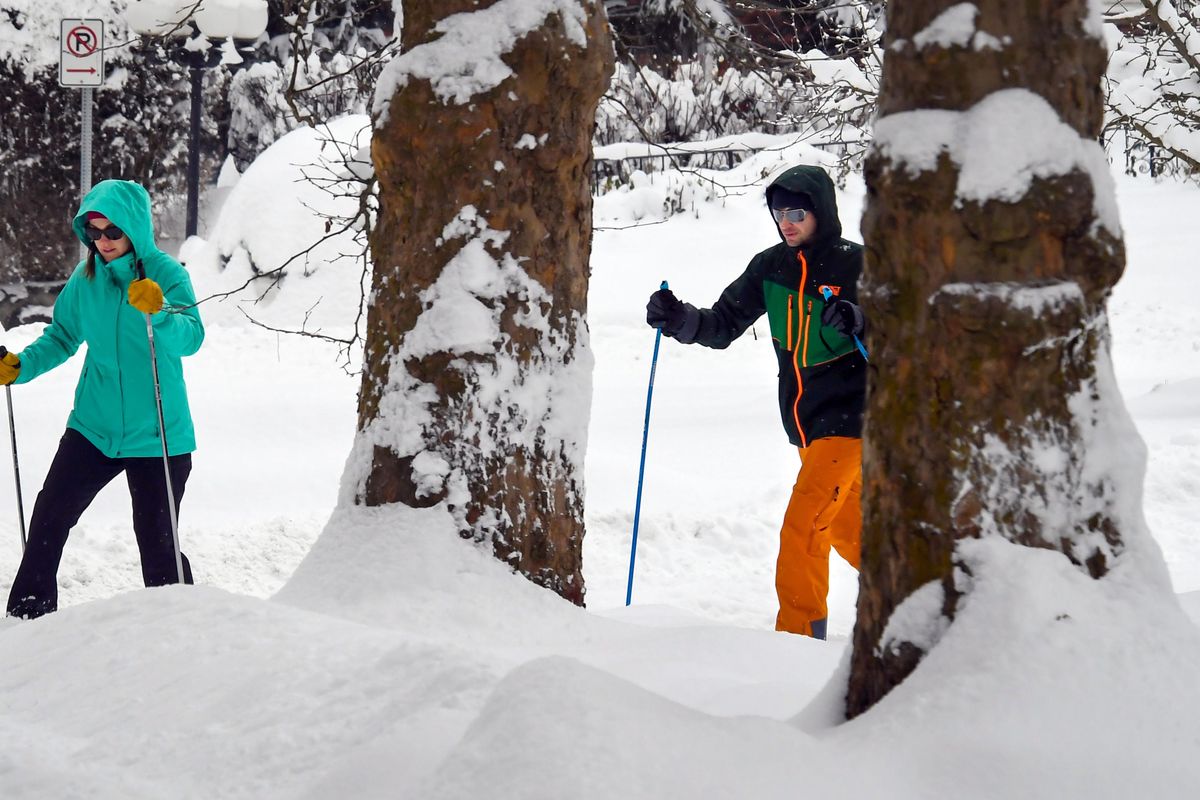 Becky Parrill. left, and Kellen Probert use cross country skis to get from 18th Avenue and Lincoln Street to the Rockwood Bakery near Manito Park, Tuesday, Feb. 12, 2019, in Spokane, Wash. Parrill is a principal assistant at Adams Elementary and was off because of a snow day. (Dan Pelle / The Spokesman-Review)