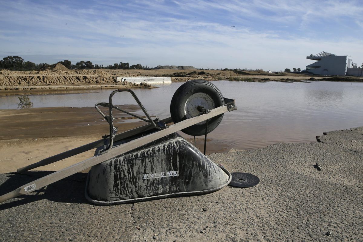 In this Jan. 13, 2016, file photo, a wheelbarrow sits at the site of the former Hollywood Park in Inglewood, Calif., where a stadium for NFL football Los Angeles Rams is being built. The opening date for the $2.6 billion football stadium under construction in Inglewood, Calif., has been pushed back one year to 2020. The Rams are financing the stadium to be shared with the Los Angeles Chargers. The delay is blamed on heavy rains that have hindered the excavation process in recent months. At right is the Hollywood Park Casino. (Damian Dovarganes / AP)