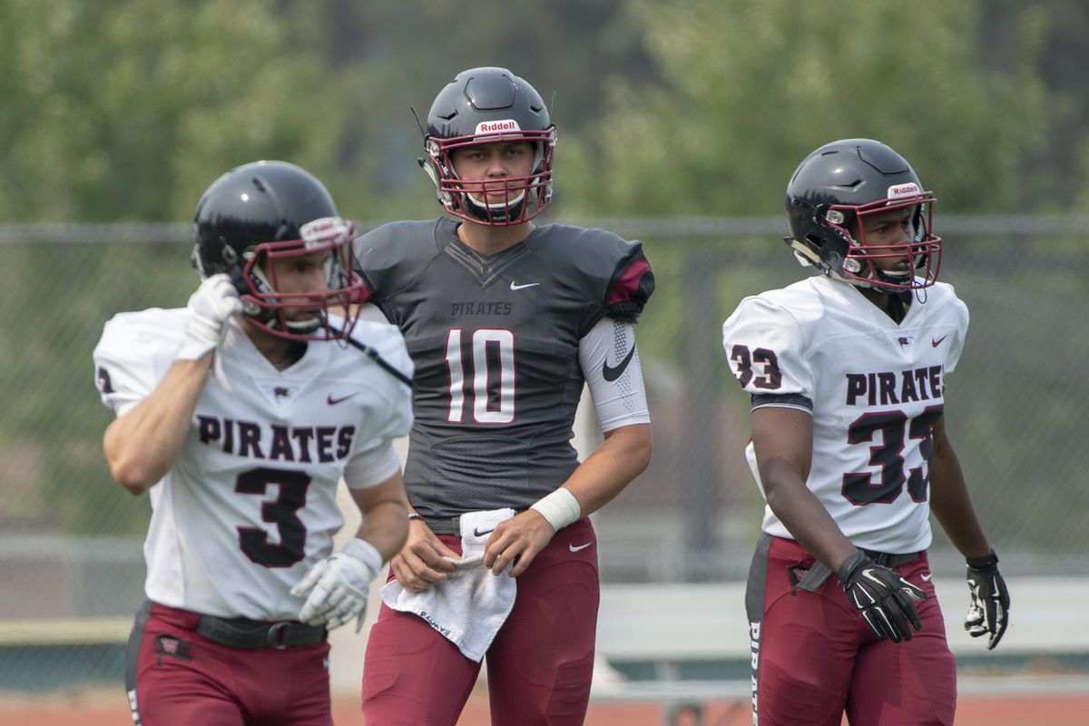Quarterback Leif Ericksen, center, receiver Garrett McKay, left, and running back Brad Mills of the Whitworth Pirates analyze the play they just completed Aug. 25  during a  scrimmage at the Pine Bowl at Whitworth University. (Jesse Tinsley / The Spokesman-Review)