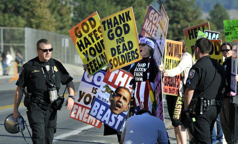 Spokane Police officers keep a close watch on members of the Westboro Baptist Church at the corner of 37th and Regal on Thursday, October 21, 2010 near Ferris High School in Spokane, Wash. (Dan Pelle / The Spokesman-Review)