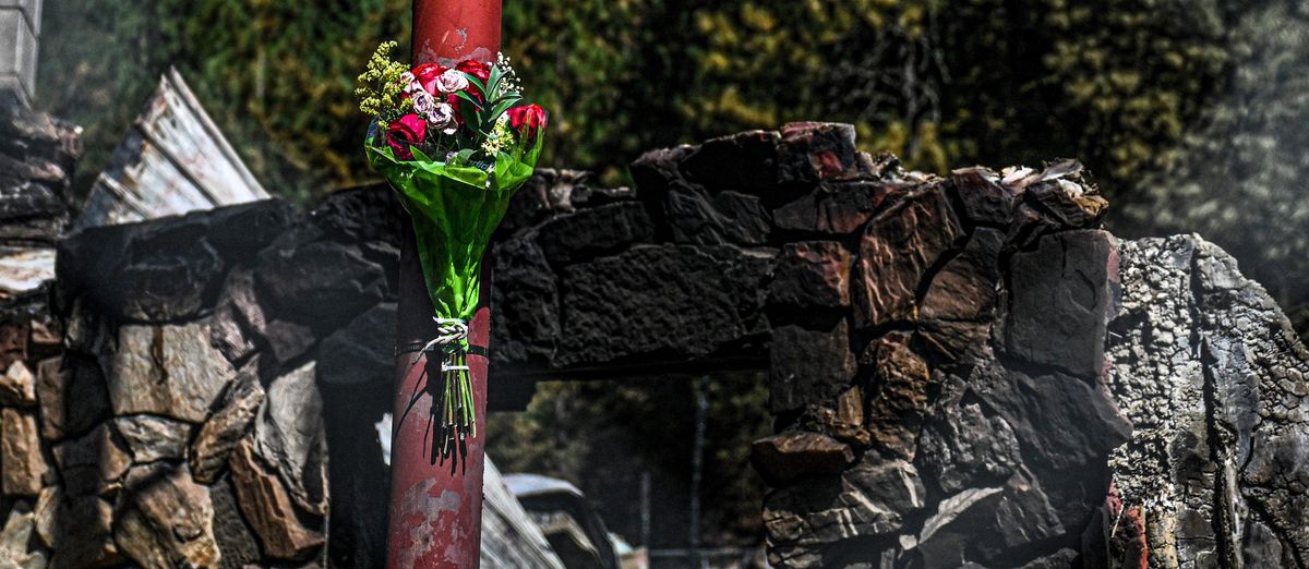 Flowers are left at the scene of the burned down Wolf Lodge Inn in Coeur d