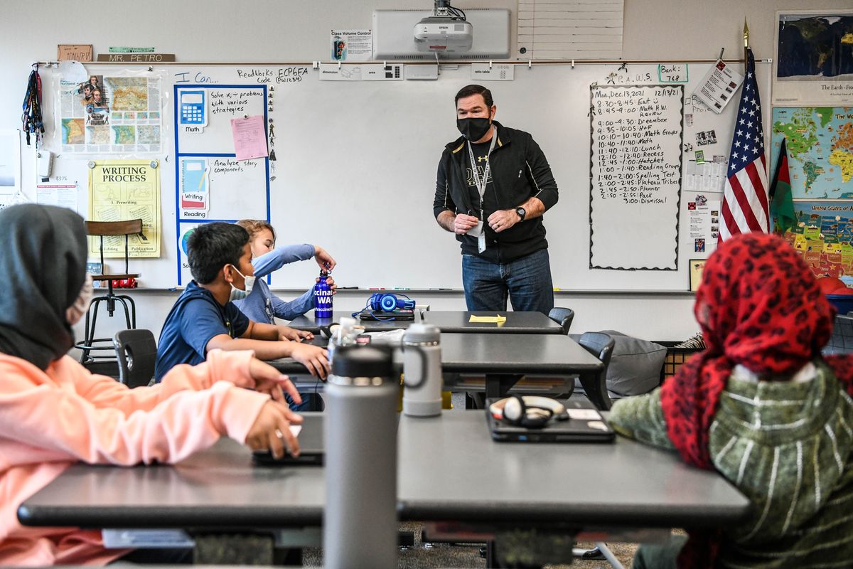 Retired pilot Lt. Col. Matthew Petro, of Fairchild Air Force Base, teaches fourth-grade students at Linwood Elementary school in Spokane. Here he begins math time Monday for Zainab Kohistani, left, and Maryam Aslami, right, both Afghan refugees.  (DAN PELLE/THE SPOKESMAN-REVIEW)