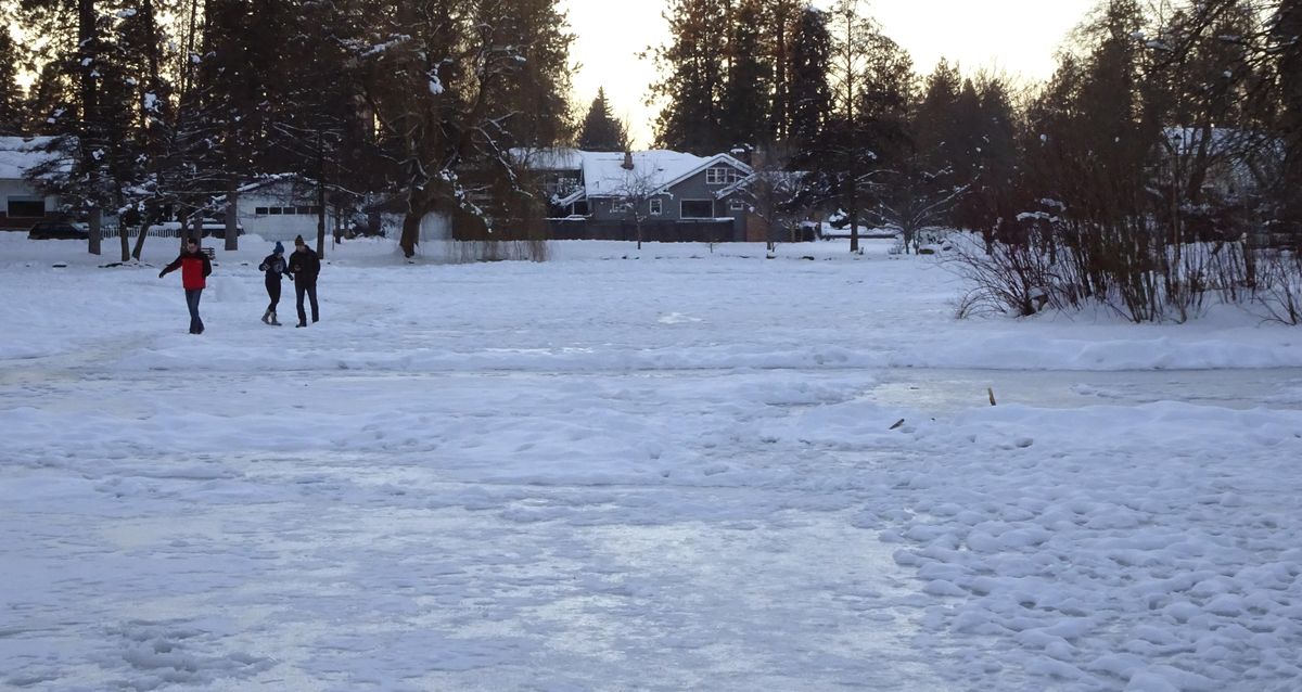 Present day:  Pedestrians test the ice on the duck pond at Manito Park in Spokane on Friday, Dec. 30, 2016. Over the past century, the natural lake has been modified and reduced in size to the current layout. (Jesse Tinsley / The Spokesman-Review)