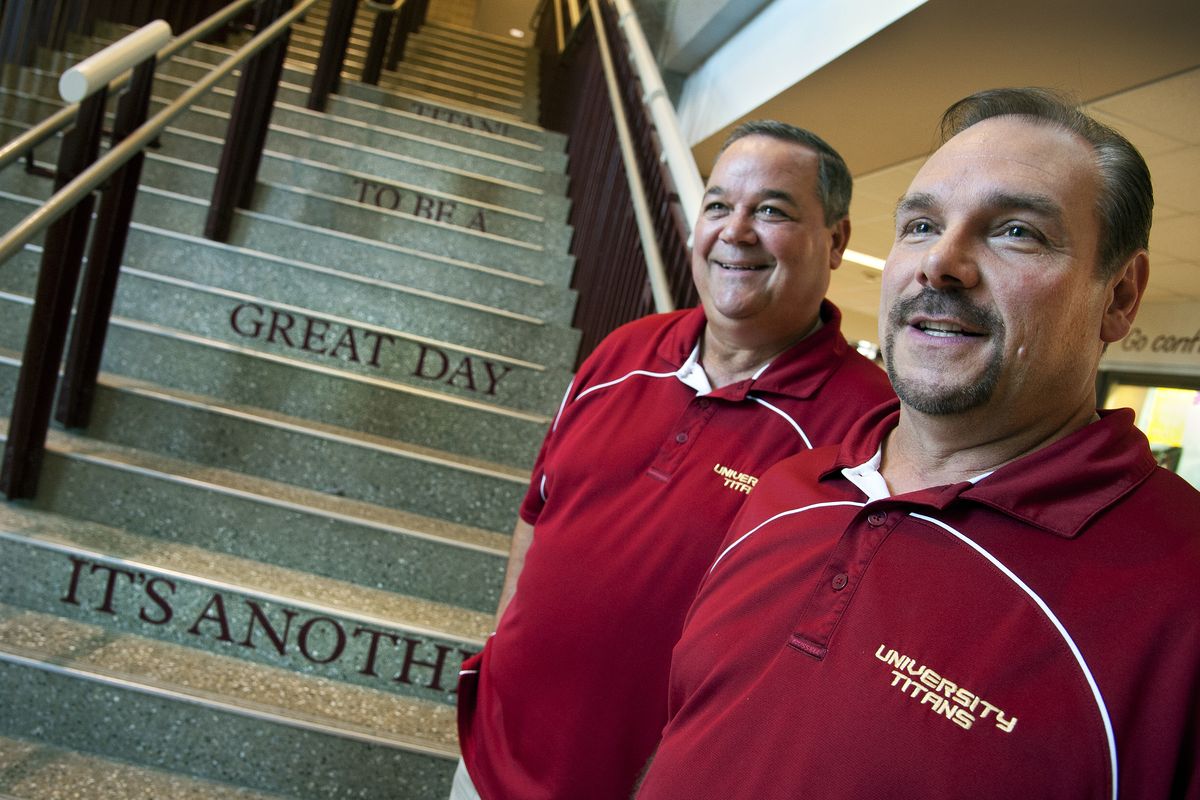 University High School classmates and friends Ken VanSickle, left, and Keven Frandsen are now back together at the school. Frandsen is interim principal and VanSickle is assistant principal. VanSickle’s daily message to students is shown on steps in the school. (Dan Pelle)