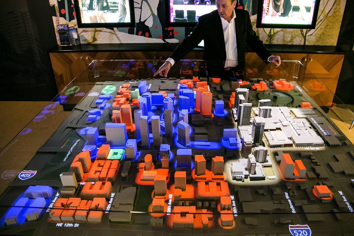 Jim Melby, president of Kemper Development Company, shows a model of downtown Bellevue. Blue represents office buildings, orange is residential, white is the Bellevue Collection (owned by Kemper), and green is for hotels. (Johnny Andrews/Seattle Times)