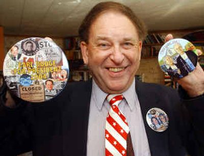 
Earl Dodge, the Prohibition Party's presidential candidate, holds his campaign button, left, and a novelty one for Bush and Kerry, right, in his office Tuesday.
 (Associated Press / The Spokesman-Review)