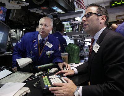 Thomas Bishop, left, and Michael Pistillo work at the New York Stock Exchange on Wednesday. (Associated Press)