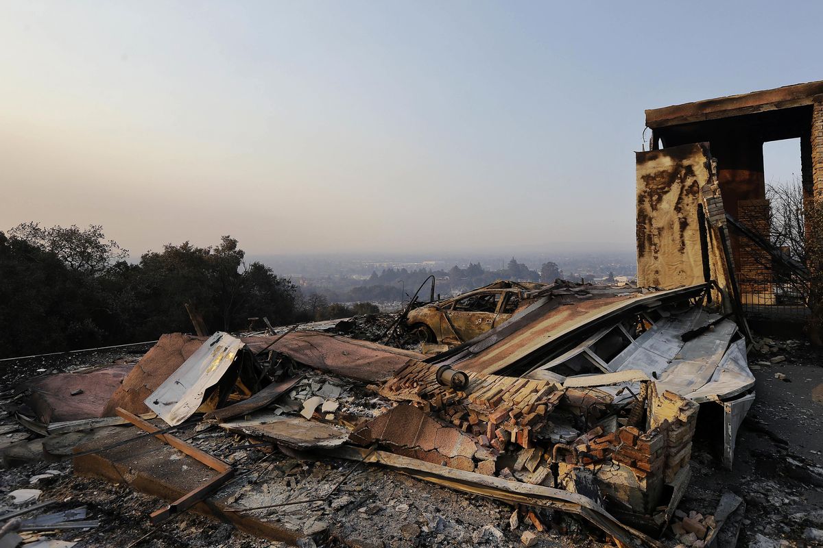 A burned out car lies among the charred remains of a home destroyed by wildfires in Santa Rosa, Calif., Thursday, Oct. 12, 2017. Gusting winds and dry air forecast for Thursday could drive the next wave of devastating wildfires that are already well on their way to becoming the deadliest and most destructive in California history. (Jeff Chiu / Associated Press)