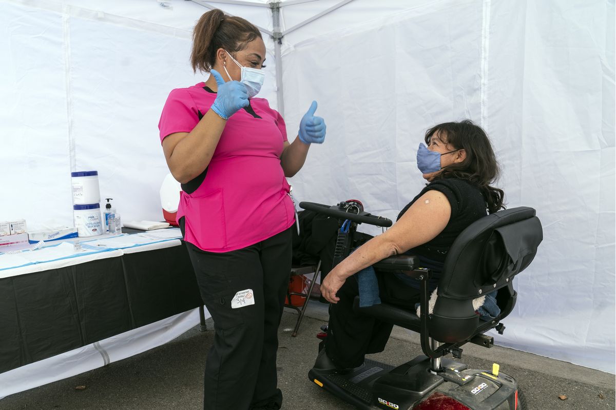 FILE - In this March 4, 2021, file photo, Veronica Lopez, who has Spina bifida, and who is a resident of the 90255 ZIP code, is vaccinated by medical assistant Keyaira Excoe at the St. John