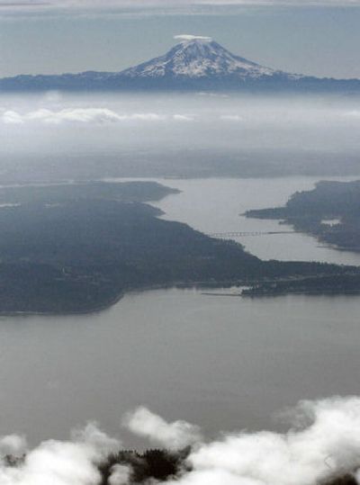 
Mount Rainier, as seen from the air overlooking the Carr Inlet and Hale Passage in Puget Sound,  draws about 2 million visitors annually, including about 10,000 who try for the 14,411-foot summit. 
 (File Associated Press / The Spokesman-Review)