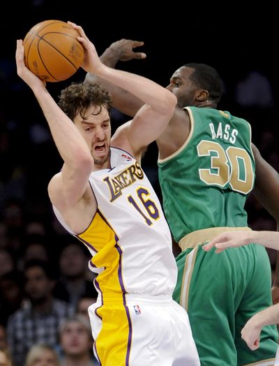 Los Angeles Lakers forward Pau Gasol (left) goes up strong to grab a rebound over Boston Celtics forward Brandon Bass. (Associated Press)