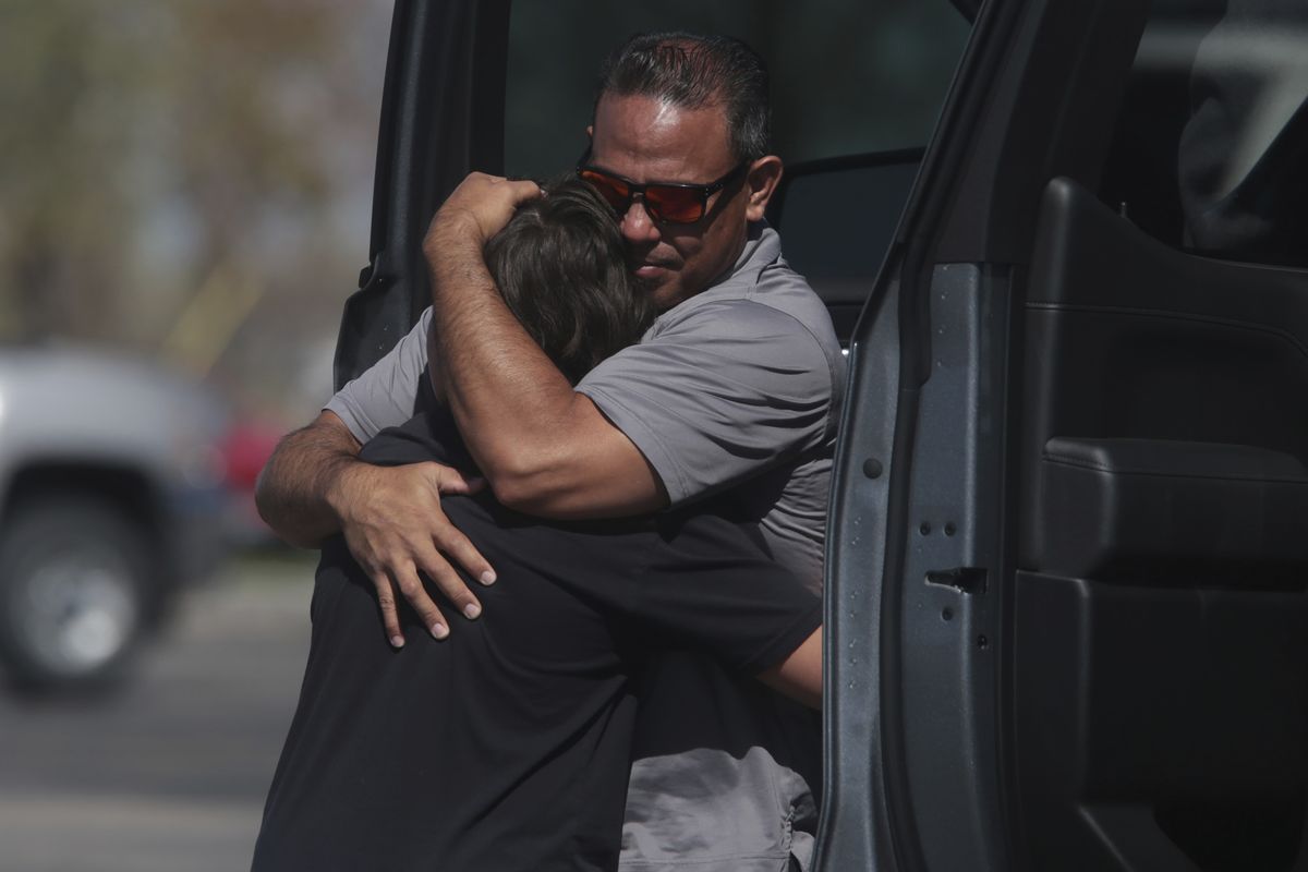 People embrace after a school shooting at Rigby Middle School in Rigby, Idaho on Thursday, May 6, 2021. Authorities say a shooting at the eastern Idaho middle school has injured two students and a custodian, and a female student has been taken into custody.  (John Roark)