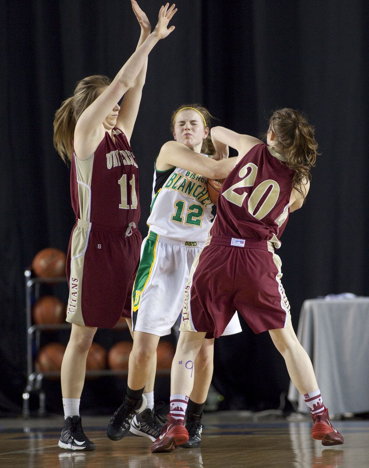 University’s Emily Terhaar, left, and Morgan Hawley, right, trap Bishop Blanchet’s Lily DePietro and draw a jump ball. The Titans had Bishop Blanchet tied up for most of the game before being outscored 19-6 in the fourth quarter to fall by five points in the State 3A opener for both teams. (Patrick Hagerty)