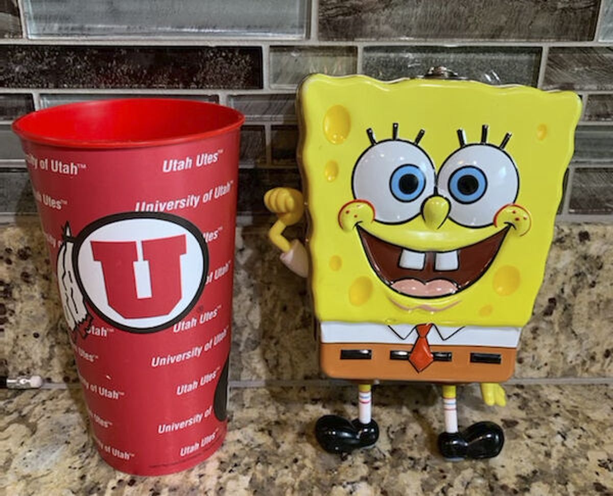 In this photo provided by Utah sports writer Andy Larsen are a childhood piggybank, right, and a plastic cup on Tuesday, Nov. 24, 2020, in Salt Lake City. Larsen