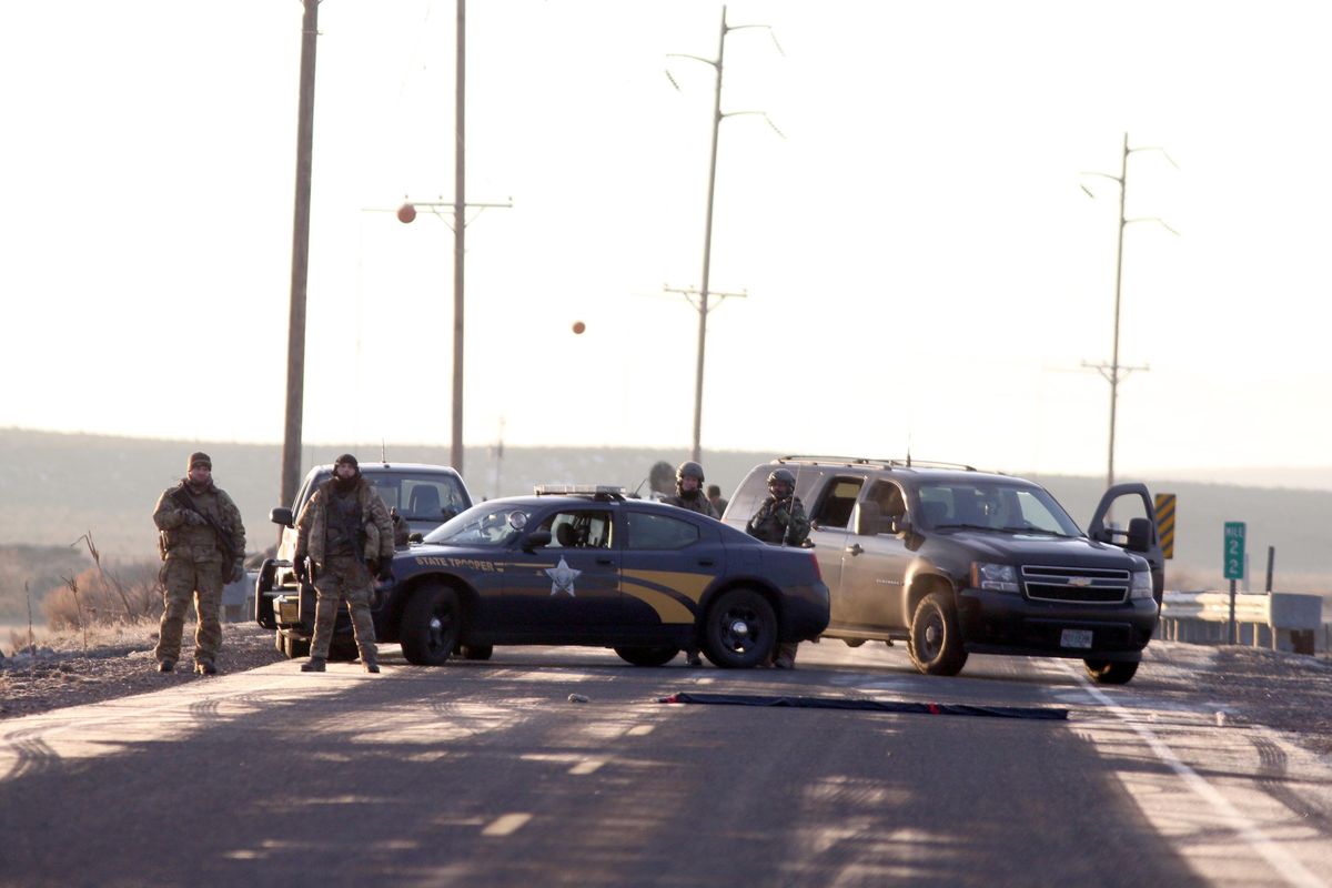 Police officers block the turnout to Sodhouse Lane, which is the main road leading to the Malheur National Wildlife Refuge headquarters, Wednesday, Jan. 27, 2016, near Burns, Ore. Authorities were restricting access on Wednesday to the Oregon refuge being occupied by an armed group after one of the occupiers was killed during a traffic stop and eight more, including the group’s leader Ammon Bundy, were arrested. (Beth Nakamura / AP)