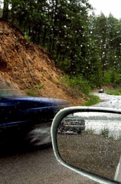 
Drivers make their way through the raindrops along Fernan Lake Road near Fernan Village on Thursday. Fernan Lake Road is one of the busiest and among the most dangerous roads in the Idaho national forest system. A massive and costly rebuild will begin in 2007. 
 (The Spokesman-Review)