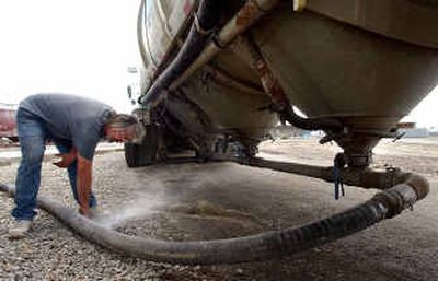 Daryl Pelletier with Gresham Transfer Inc. checks a small leak in the hose while he was unloading slag, an additive mixed in with cement, at the Lafarge Corp. cement facility at the Spokane Business and Industrial Park on Thursday.
(Liz Kishimoto / The Spokesman-Review)