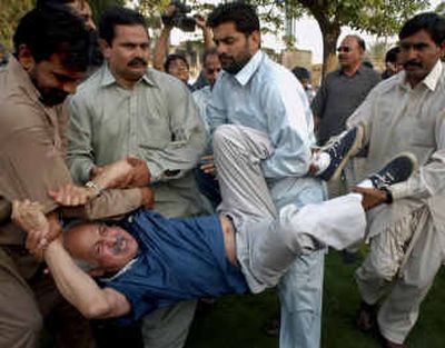 
Pakistani plainclothes police officers arrest Iqbal Haider, an opposition lawmaker who was trying to participate in a road race in Lahore, Pakistan, on Saturday. Pakistani police detained about 30 people for defying a ban on women running in a road race in Lahore, witnesses and police said. 
 (Associated Press / The Spokesman-Review)