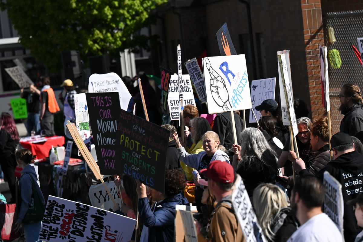 Protesters cheer as runners with the Bloomsday Elite Men’s Race passes Sunday in Spokane.  (Tyler Tjomsland/The Spokesman-Review)