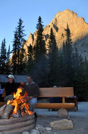 Hikers relax by the fire pit at the Lake O'Hara Campground as the sun sets on the Wiwaxy Peaks looming above Lake O'Hara in Yoho National Park, British Columbia.
 (Rich Landers)
