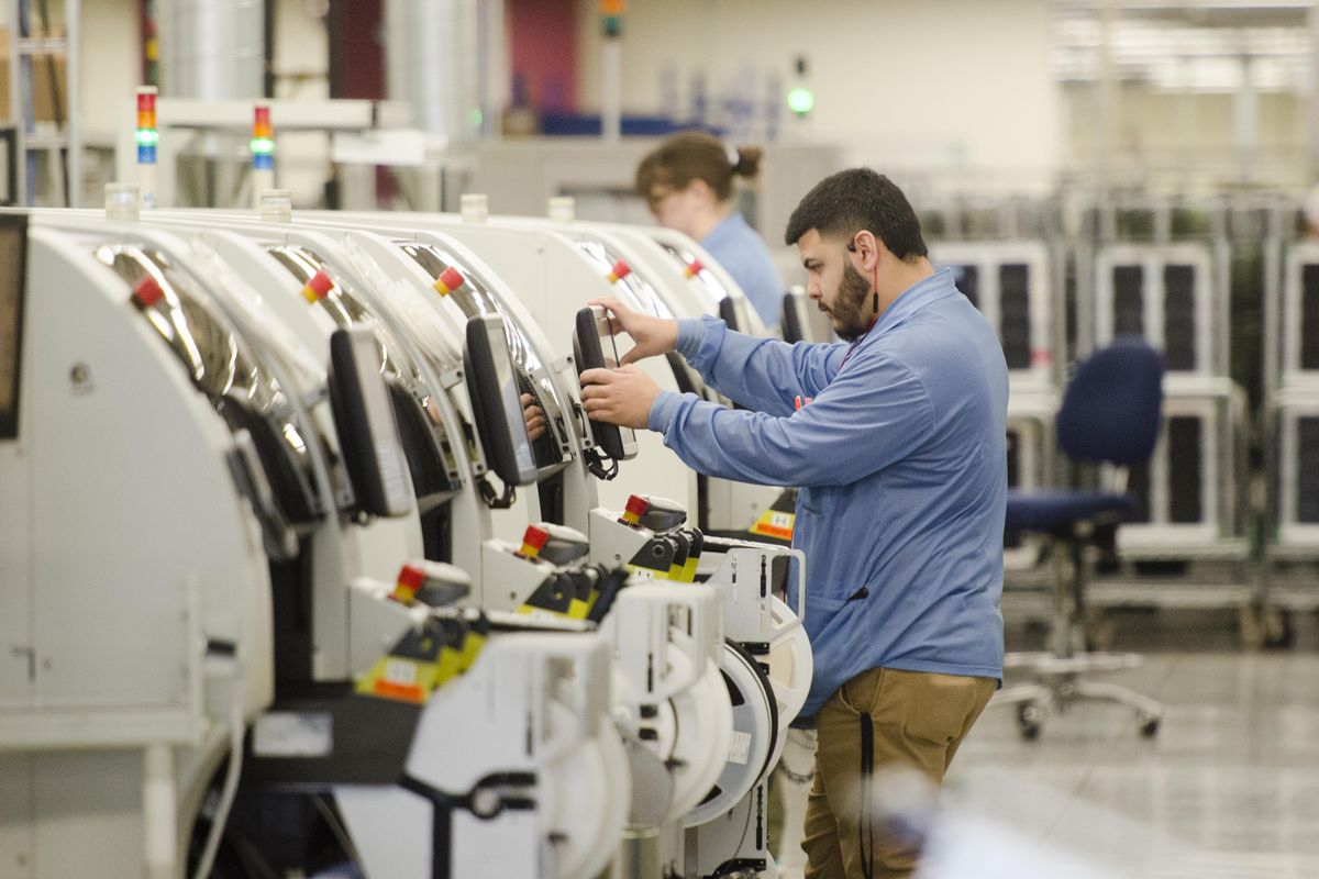 An employee at Schweitzer Engineering Laboratories in Pullman moves among several machines making circuit boards that will go into equipment destined for the energy industry on Tuesday, April 19, 2016. SEL has seen explosive growth in their products and their workforce in recent years. (Jesse Tinsley / The Spokesman-Review)