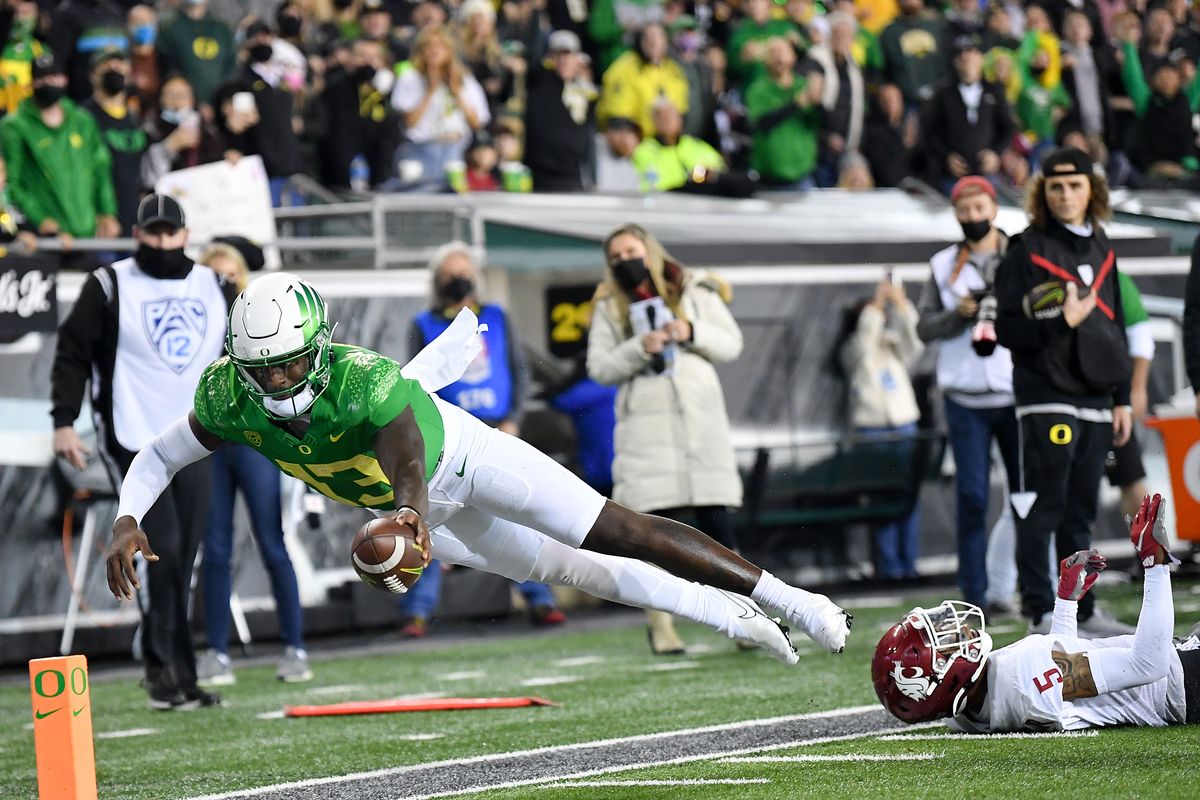 Oregon Ducks quarterback Anthony Brown (13) leaps past Washington State Cougars defensive back Derrick Langford (5) and into the end zone for a touchdown during the second half of a college football game on Saturday, Nov 13, 2021, at Autzen Stadium in Eugene, Ore. Oregon won the game 38-24.  (Tyler Tjomsland/The Spokesman-Review)