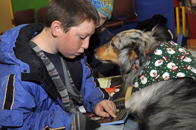 Ahron McArney, 13, of Middleton, Idaho reads to therapy dog Skye, a 6-year-old Sheltie during the 