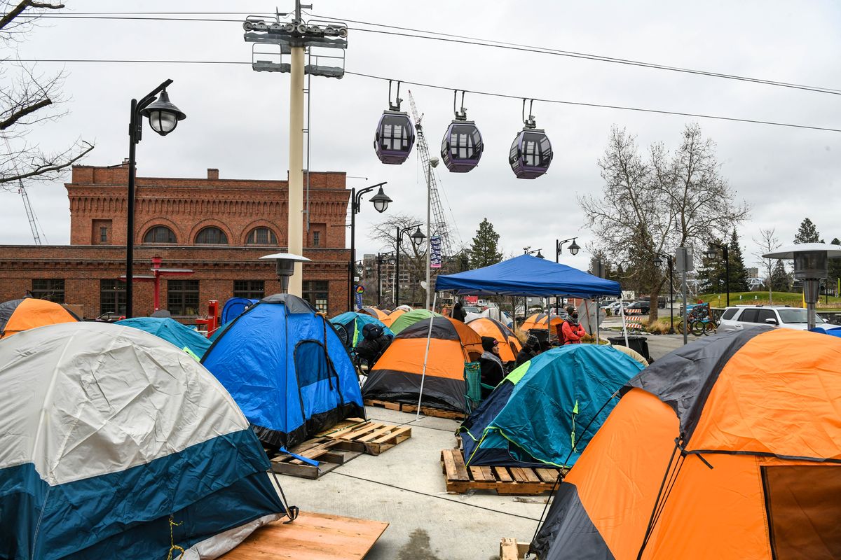 The Numerica SkyRide passes over the camping tents pitched in the shadow of Spokane City Hall as part of a protest to gain more beds for the homeless, Friday, Dec. 10, 2021.  (DAN PELLE/THE SPOKESMAN-REVIEW)