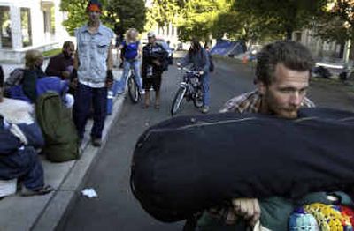 
Justin Estes packs his belongings on his bike after being asked to leave the camp that he and about 50 other homeless people set up to protest the transient camping ordinance in July. 
 (Jed Conklin / The Spokesman-Review)