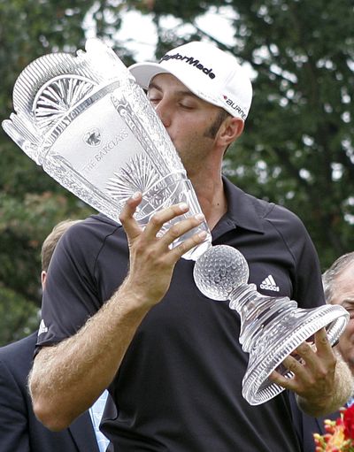 Dustin Johnson kisses the championship trophy after winning The Barclays in the hurricane-shortened golf tournament on Saturday. (Associated Press)