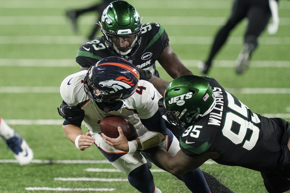 New York Jets defensive tackle Quinnen Williams (95) grabs the face mask of Denver Broncos quarterback Brett Rypien (4) during the second half of an NFL football game Thursday, Oct. 1, 2020, in East Rutherford, N.J. Williams was called for a penalty.  (Associated Press)
