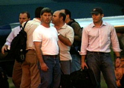 
American airplane pilots Joseph Lepore, center with T-shirt, and Jan Palladino, right with baseball cap, who were flying the executive jet that clipped an airliner last Sept. 29, wait for a flight in the airport of Cuiaba, Brazil, on Oct. 1. 
 (Associated Press / The Spokesman-Review)
