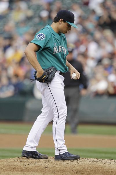 Seattle Mariners starting pitcher Jason Vargas pauses on the mound after giving up a solo home run to San Francisco Giants' Buster Posey in the second inning of a baseball game, Friday, June 15, 2012, in Seattle. (Ted Warren / Associated Press)