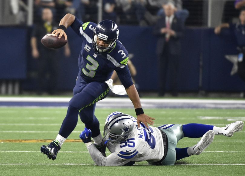 Seahawks QB Russell Wilson (3) breaks away from a tackle attempt by Cowboys’ Rolando McClain in the second half Sunday’s game. (Michael Ainsworth / AP)