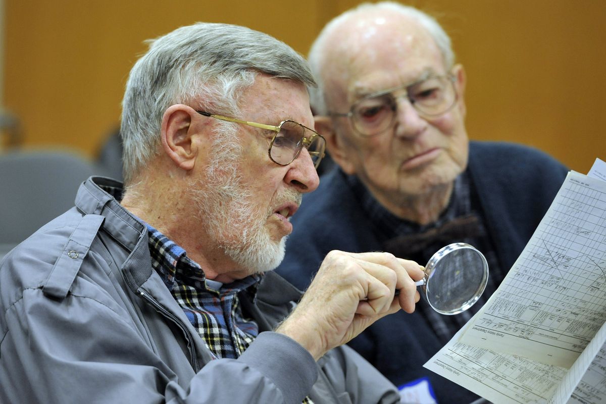 John Stuart, 84, and John Ellingson, 90, right, look over Stuart’s census papers during a visit to the Eastern Washington Genealogical Society’s 1940s census party Saturday at the Spokane Public Library Main Branch. (Dan Pelle)