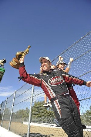 Larry Dixon climbs the fence after his victory at Indy. (Photo courtesy of NHRA)