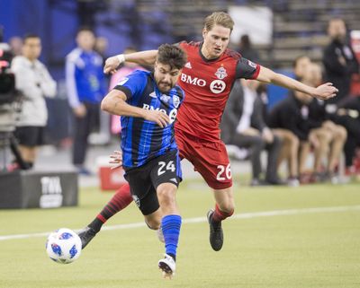Montreal Impact midfielder Mike Petrasso (24) challenges Toronto FC midfielder Nicolas Hasler (26) during Saturday’s game. Montreal won 1-0. (Ryan Remiorz / Associated Press)