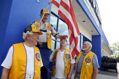 From left, Cliff Johnson, Dick Holling, Jerry Murphy and Dick Odell stand in front of Alton’s on the South Hill, a client in the Lions’ flag program. (Jesse Tinsley / The Spokesman-Review)