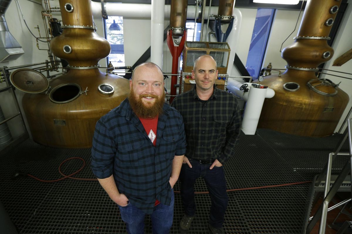 Matt Hofmann, the master distiller at Westland Distillery, and Steven Hawley, director of marketing, stand in the still room of the distillery in Seattle. (Associated Press)