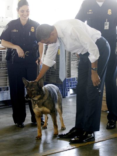 President Barack Obama pets a Customs and Border Patrol dog during his tour of the Bridge of America Cargo Facility in El Paso, Texas, on Tuesday. (Associated Press)