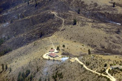 Fire burned up to the edge of this home north of Lake Chelan on Wednesday. Spokane firefighters joined the battle against the wildfire, which officials said was 20 percent contained Wednesday evening.  (Colin Mulvany / The Spokesman-Review)