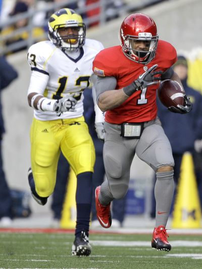 Ohio State running back Dan Herron (right) runs away from Michigan safety Carvin Johnson.  (Associated Press)