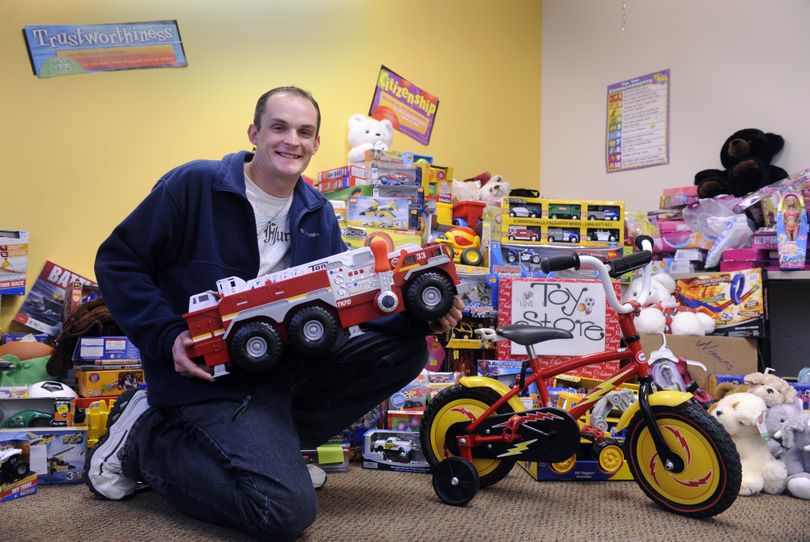 Luke Pillsbury, director of youth ministries for Opportunity Presbyterian Church on Pines Road, sits with some of the toys for the church’s toy store, where community members who are invited can get toys at a deep discount. (Jesse Tinsley)