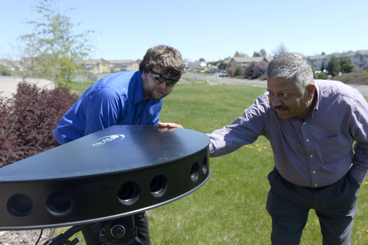 Matthew Poppe and Jay Jayaram look at the camera head they have developed at the 3D-4U headquarters in Pullman recently. The camera takes a 180-degree stereo video image that can be panned and zoomed by the viewer of a live event or of a prerecorded video. (Jesse Tinsley)