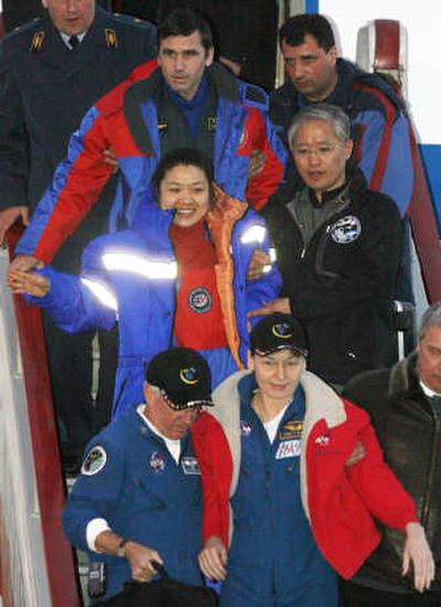 
Space agency officials help American Peggy Whitson, bottom, South Korean Yi So-yeon, center, and Russian Yuri Malenchenko on their arrival at the Chkalovsky airport Saturday. Associated Press
 (Associated Press / The Spokesman-Review)