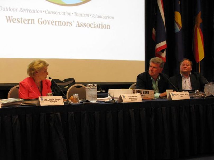 Washington Gov. Chris Gregoire, left, incoming WGA chair, talks with outgoing chair Idaho Gov. Butch Otter, right, as he hands over the chairmanship of the group on Thursday. (Betsy Russell)