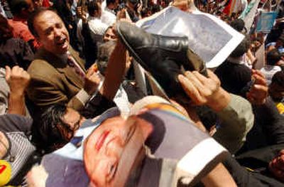 
Protesters destroy posters of Egyptian President Hosni Mubarak in Cairo during a national referendum Wednesday. 
 (Associated Press / The Spokesman-Review)