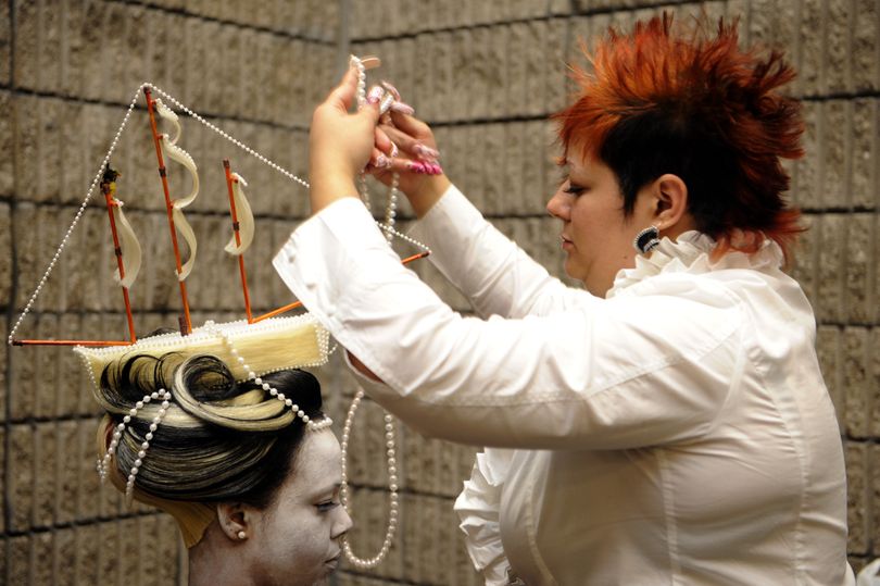 Yolanda Turner, 34, of Head Turner Styling Studio in Greensboro, N.C., puts a string of pearls around her model, Dionne Battle, 32, left, to enhance the Titanic-theme fantasy hairstyle she creates backstage before the Bronner Brothers Fantasy Hair Show in Atlanta, Sunday, Feb 21, 2010. The fantasy competition allows the hair stylist to be as creative as possible crafting a look that involves not only hair but also make-up and clothes. (Elissa Eubanks / The Atlanta Journal & Constituti)