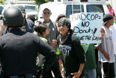 
A protester confronts police officers who came to evict farmers from a 14-acre urban farm in South Los Angeles on Tuesday. 
 (Associated Press / The Spokesman-Review)