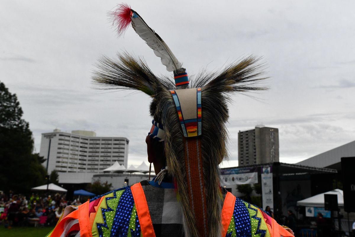 Talon Addison, 11, is stands against the Spokane skyline as he waits to dance with his family during the Gathering at the Falls Powwow on Friday, Aug. 23, 2019, at Riverfront Park in Spokane, Wash. (Tyler Tjomsland / The Spokesman-Review)